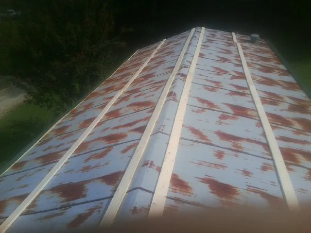 Rusted metal roof panels with new wood purlins before replacement — Storm Damage Roof Repair in Columbia by Roofing Brothers
