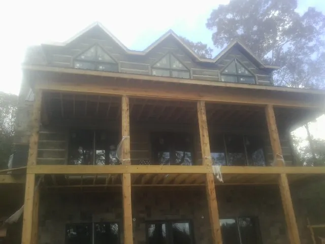 Dormers and porch framing on a large log home under construction — Roof Coating work by our crew in Columbia