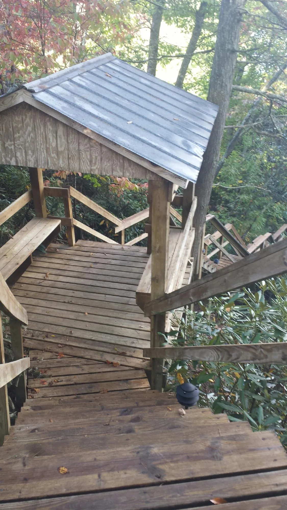 Metal roofed shelter over wooden steps on a wooded walkway — Skylight Repair & Installation work by our crew in Columbia